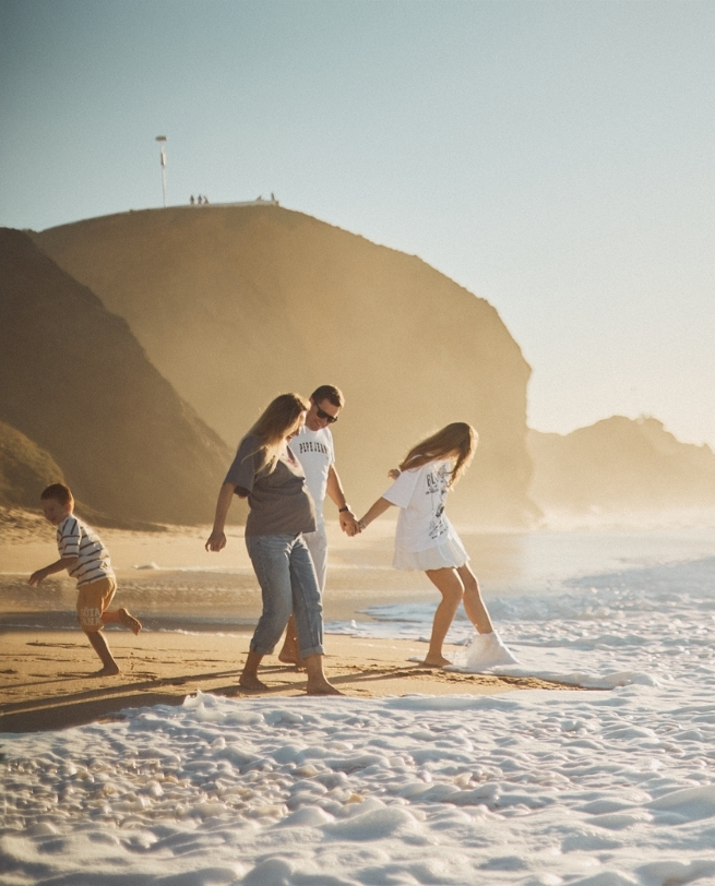 Família correndo juntos na praia